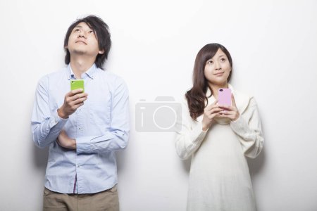 Photo for Young asian couple with smartphones - Royalty Free Image