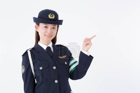 Téléchargez les photos : Portrait studio d'une policière japonaise pointant du doigt - en image libre de droit