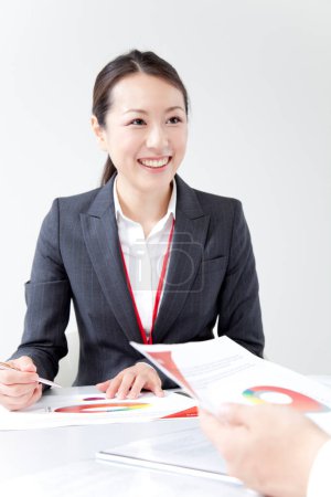 Téléchargez les photos : Portrait de belle jeune femme d'affaires japonaise faisant de la paperasse avec un collègue isolé sur blanc - en image libre de droit