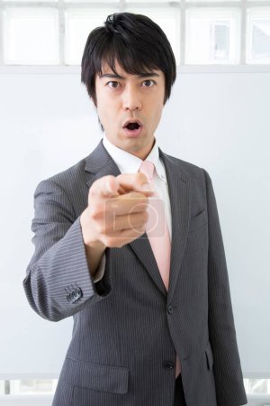 Japanese businessman gesturing in office 
