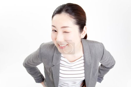 Photo for Young asian woman winking, studio shot - Royalty Free Image