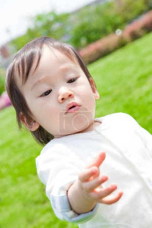 Photo for Cute little japanese child playing in summer park - Royalty Free Image