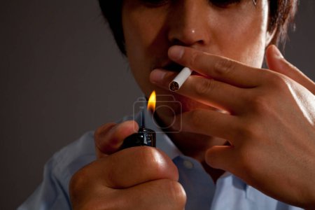 Téléchargez les photos : Jeune asiatique homme fumer une cigarette w - en image libre de droit