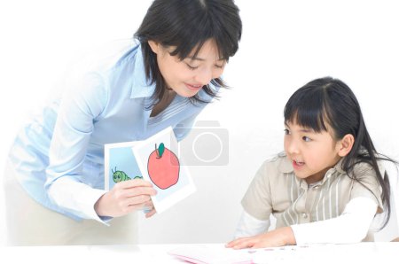 Photo for Studio portrait of young Japanese mother and daughter studying - Royalty Free Image