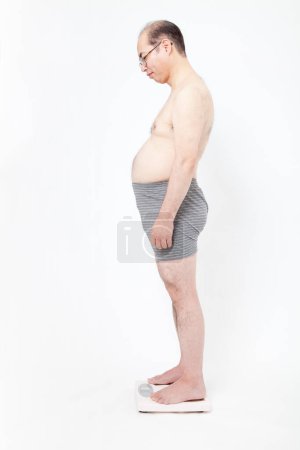 Foto de Hombre gordo japonés en ropa interior con básculas de peso. Concepto de perder peso - Imagen libre de derechos