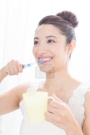 Téléchargez les photos : Asiatique femme brossant ses dents - en image libre de droit