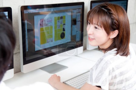 Téléchargez les photos : Asiatique femme en utilisant un ordinateur à l'intérieur - en image libre de droit