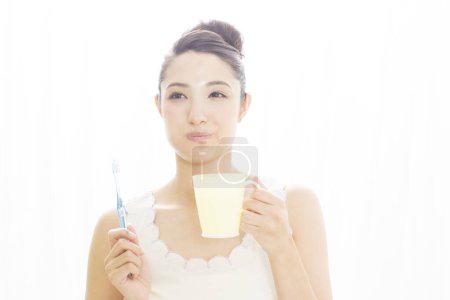 Téléchargez les photos : Asiatique femme brossant ses dents - en image libre de droit