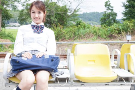 Téléchargez les photos : Jeune asiatique femelle étudiant assis sur banc - en image libre de droit