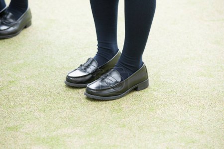Photo for Female legs wearing black shoes - Royalty Free Image