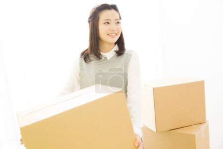 Téléchargez les photos : Belle femme japonaise avec des boîtes en carton à la maison - en image libre de droit