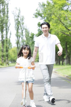 Foto de Asiático padre y hija caminando en el parque - Imagen libre de derechos