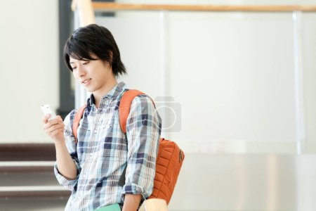 Foto de Joven asiático hombre con smartphone en hall - Imagen libre de derechos