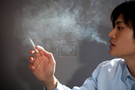 Photo for Asian man smoking cigarette - Royalty Free Image