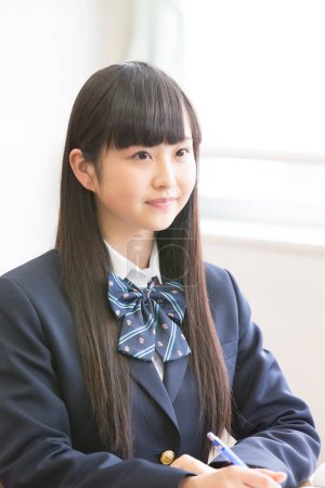 Photo for Beautiful japanese schoolgirl studying at school - Royalty Free Image