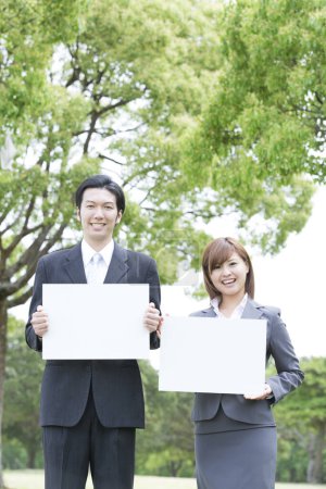 Foto de Gente de negocios sosteniendo carteles en blanco al aire libre - Imagen libre de derechos