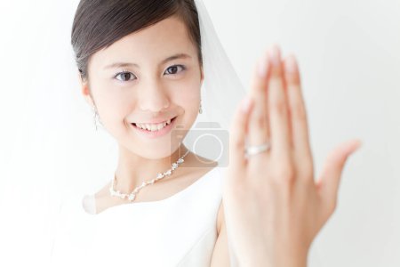Foto de Una mujer en un vestido de novia está sosteniendo su mano - Imagen libre de derechos