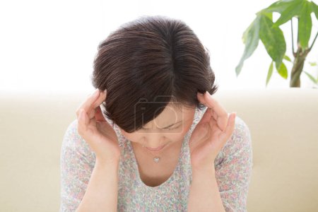 Foto de Mujer asiática que sufre de dolor de cabeza - Imagen libre de derechos
