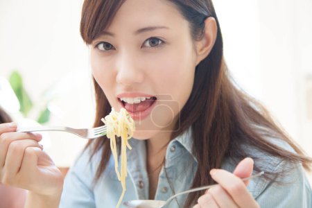 Foto de Joven asiático mujer comer fideos - Imagen libre de derechos