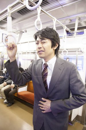 Téléchargez les photos : Portrait d'un homme d'affaires japonais adulte allant travailler dans le métro - en image libre de droit