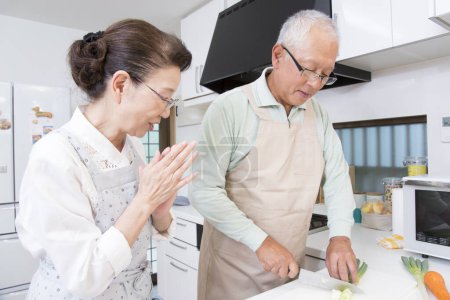 Téléchargez les photos : Senior couple cuisine ensemble dans la cuisine - en image libre de droit