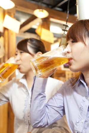 Foto de Dos mujeres bebiendo cerveza en un bar - Imagen libre de derechos