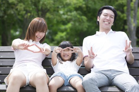 portrait of young asian family with victory gestures  in the park