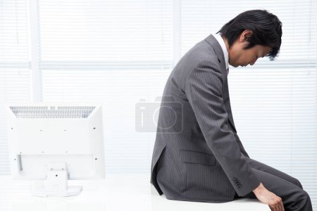 Foto de Retrato de adulto deprimido japonés hombre de negocios en la oficina - Imagen libre de derechos