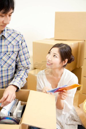 Téléchargez les photos : Couple asiatique avec des boîtes en carton se déplaçant dans une nouvelle maison - en image libre de droit