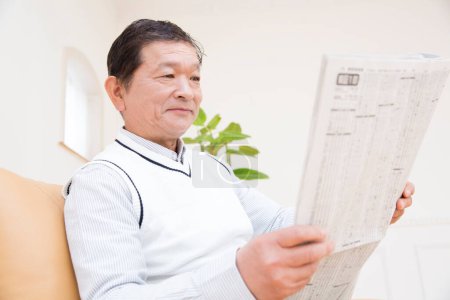 Photo for Senior man reading newspaper at home - Royalty Free Image