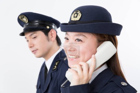 Téléchargez les photos : Portrait studio de policiers japonais répondant à un appel téléphonique - en image libre de droit