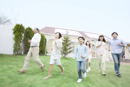 Téléchargez les photos : Portrait de grande famille japonaise courant près de la maison - en image libre de droit