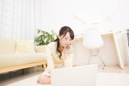 Foto de Asiática joven mujer usando ordenador portátil en casa - Imagen libre de derechos