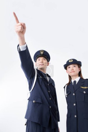 Téléchargez les photos : Portrait studio de policiers japonais en uniforme pointant du doigt - en image libre de droit