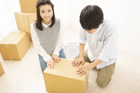 Photo for Beautiful Japanese woman with cardboard boxes at home - Royalty Free Image