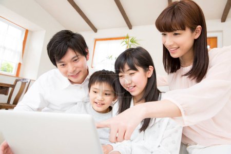 Photo for Portrait of happy Japanese family with laptop at home - Royalty Free Image