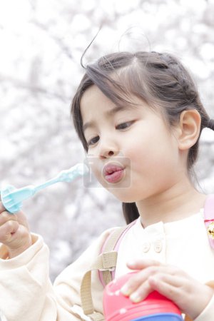 Téléchargez les photos : Asiatique petite fille soufflant bulles de savon - en image libre de droit