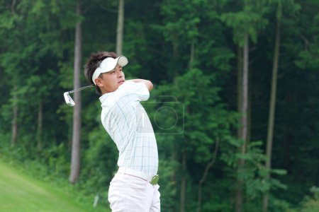 Photo for Young Japanese man playing golf at daytime - Royalty Free Image