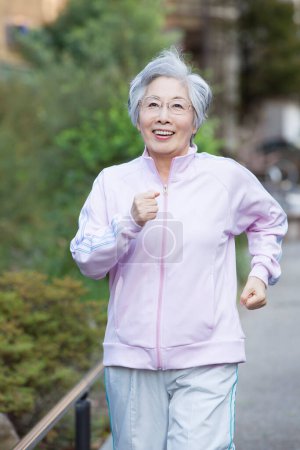 Photo for Senior asian woman running in the city. - Royalty Free Image