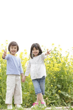 Photo for Cute Japanese children on rapeseed field - Royalty Free Image