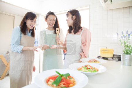Photo for Portrait of three smiling young Japanese women cooking together - Royalty Free Image