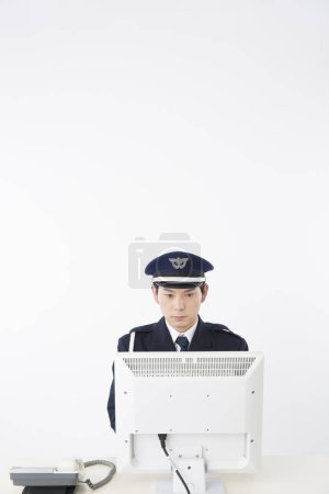 Foto de Retrato de estudio del oficial de policía japonés con computadora - Imagen libre de derechos