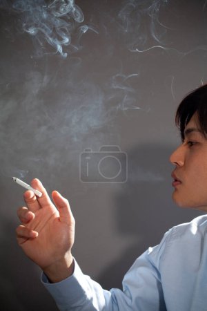 Foto de Joven asiático hombre fumar cigarrillo - Imagen libre de derechos