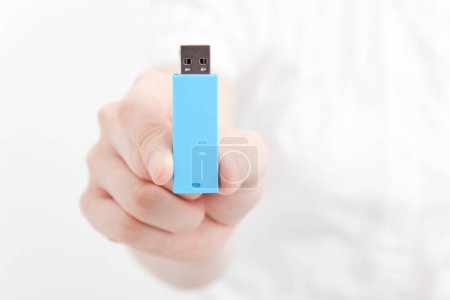 Foto de Mano sosteniendo una memoria USB azul sobre fondo aislado. - Imagen libre de derechos