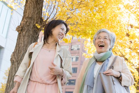 Photo for Happy senior and mature japanese women strolling in autumn park - Royalty Free Image