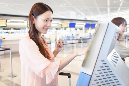 Téléchargez les photos : Heureux asiatique jeune femme avec bagages dans aéroport - en image libre de droit