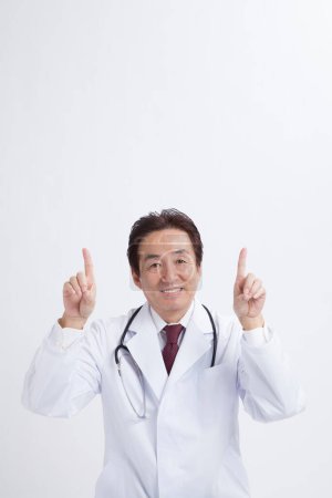 Foto de Asiático mayor médico con estetoscopio apuntando hasta - Imagen libre de derechos
