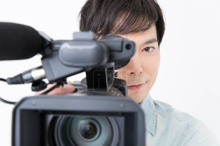 Téléchargez les photos : Jeune asiatique homme enregistrement vidéo avec caméra - en image libre de droit