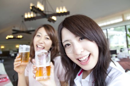 Photo for Young women drinking beer in bar - Royalty Free Image
