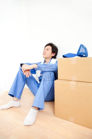 Photo for Young Japanese delivery man with cardboard boxes - Royalty Free Image
